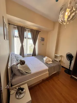 a bedroom with a bed with a window and a lamp at Bayview near PICC CCP starcity OKADA Airport MOA in Manila