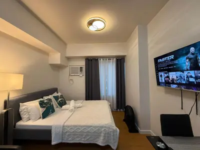 a bedroom with a bed and a flat screen tv at Manila Bay Views City Delights Stay near St Lukes and US Embassy in Ermita Manila in Manila