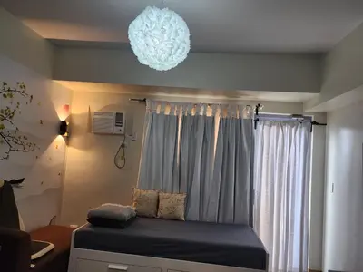 a bedroom with a bed and a chandelier at DG CONDOTEL @MANHATTAN PLAZA T2 STUDIO WITH BALCONY , 50 INCH TV AND UNLI WIFI @Araneta Cubao Quezon City Philippines in Manila