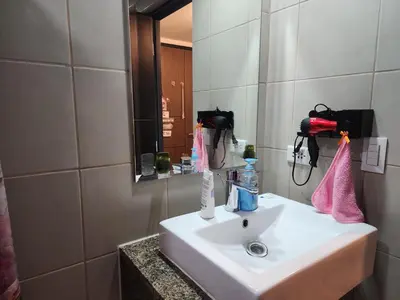 a bathroom with a white sink and a mirror at DG CONDOTEL @MANHATTAN PLAZA T2 STUDIO WITH BALCONY , 50 INCH TV AND UNLI WIFI @Araneta Cubao Quezon City Philippines in Manila