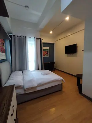 a bedroom with a bed and a television in it at Yuanhang 1508 in Manila