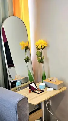 a table with a mirror and a vase with yellow flowers at Guest Favorite House in Biñan in Biñan
