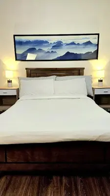 a large white bed with a painting on the wall at Guest Favorite House in Biñan in Biñan