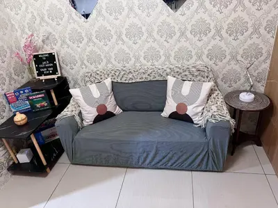 a couch in a living room with two pillows on it at JAL's Cozy Haven in Manila