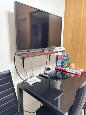 a desk with a television on top of it at JAL's Cozy Haven in Manila