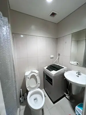 a bathroom with a toilet and a sink at JAL's Cozy Haven in Manila