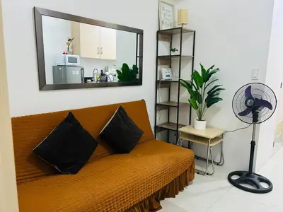 a room with a couch with a mirror and a fan at SMDC Light Residences Condominium in Manila
