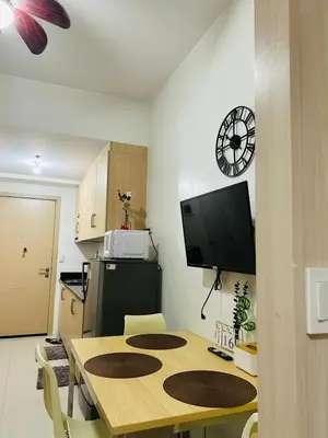 a kitchen with a table and a tv in a room at SMDC Light Residences Condominium in Manila