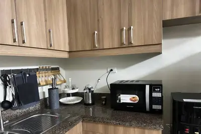 a kitchen with a counter top with a microwave at 3BR Resort Style Condo in Manila