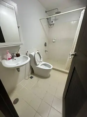 a bathroom with a toilet and a sink and a shower at 3BR Resort Style Condo in Manila