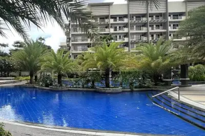 a large swimming pool with palm trees in front of a building at 3BR Resort Style Condo in Manila