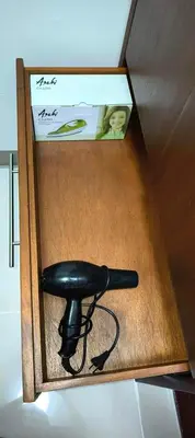 a black hair dryer in a wooden box at Cozy Two Bedroom Family Suites at Coast Residences near PICC, WTC & MOA in Manila