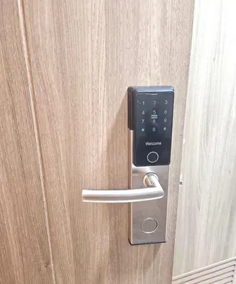 a metal door with a handle on a wooden door at Cozy Two Bedroom Family Suites at Coast Residences near PICC, WTC & MOA in Manila
