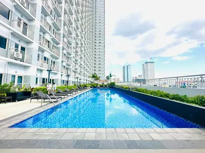 a swimming pool in the middle of a building at Cozy Two Bedroom Family Suites at Coast Residences near PICC, WTC & MOA in Manila