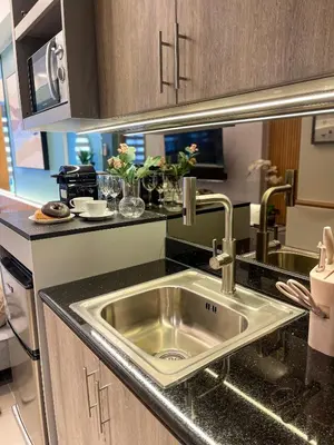 a kitchen with a stainless steel sink in a kitchen at Family suite by SMDC fame residence 5 mins to Shaw mrt,megamall,ortigas in Manila