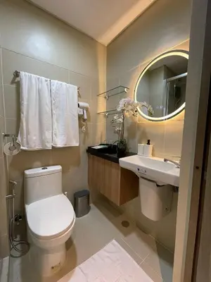 a bathroom with a toilet and a sink and a mirror at Family suite by SMDC fame residence 5 mins to Shaw mrt,megamall,ortigas in Manila