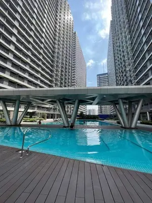 a bridge over a pool in a city with tall buildings at Family suite by SMDC fame residence 5 mins to Shaw mrt,megamall,ortigas in Manila