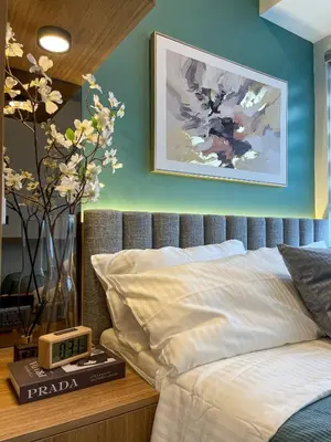 a bedroom with a bed with a clock on a table at Family suite by SMDC fame residence 5 mins to Shaw mrt,megamall,ortigas in Manila