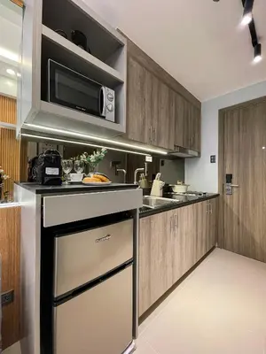 a kitchen with a microwave above a stove at Family suite by SMDC fame residence 5 mins to Shaw mrt,megamall,ortigas in Manila