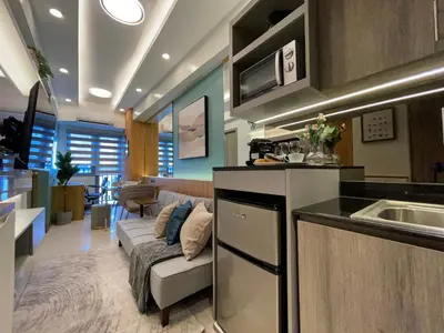 a kitchen and a living room with a couch at Family suite by SMDC fame residence 5 mins to Shaw mrt,megamall,ortigas in Manila