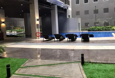 a hotel lobby with chairs and a swimming pool at C Place - Capsule B - Upper in Manila