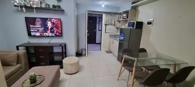 a living room with a glass table and a kitchen at Elegant 2BR Condo unit with free WiFi in Anabu Primero