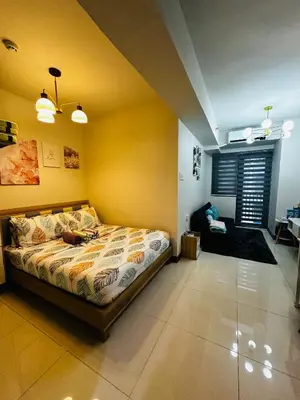 a bedroom with a bed and a couch in it at Serendipity Suite at S Residences in Manila