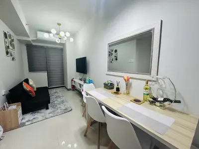 a dining room with a table and chairs in a room at Serendipity Suite at S Residences in Manila
