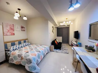a bedroom with a bed and a desk at Serendipity Suite at S Residences in Manila
