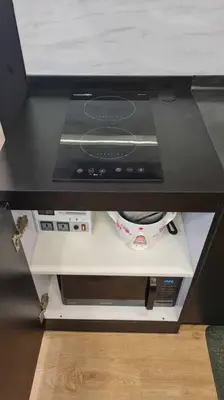 a kitchen counter with a stove and a microwave at California Themed Condo in BGC in Manila