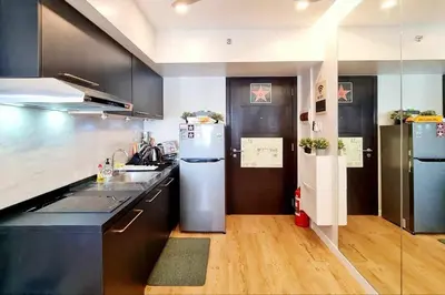 a kitchen with a refrigerator and a sink at California Themed Condo in BGC in Manila