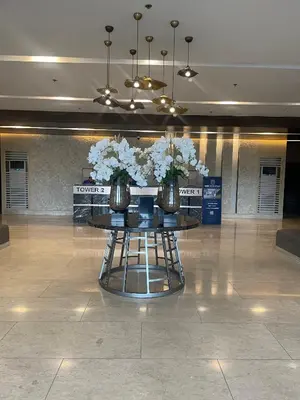 a table with two vases with white flowers on it at Molly Shore Getaway Unit 1277 in Manila