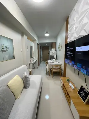 a living room with a white couch and a tv at Molly Shore Getaway Unit 1277 in Manila