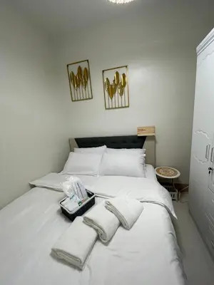 a bedroom with a white bed with towels on it at Molly Shore Getaway Unit 1277 in Manila