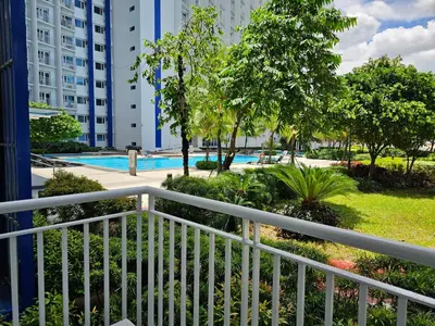 a balcony with a view of a pool and buildings at Luxury lodgings by PN Leonardo in Manila