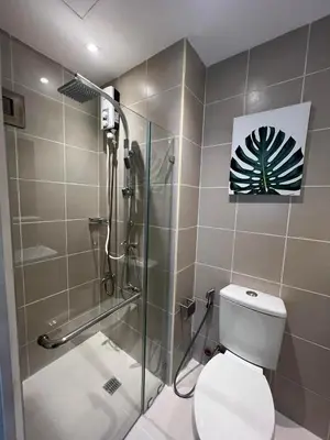 a bathroom with a shower and a toilet with a glass door at Luxury lodgings by PN Leonardo in Manila