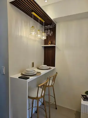 a kitchen with two chairs and a counter with plates at Luxury lodgings by PN Leonardo in Manila