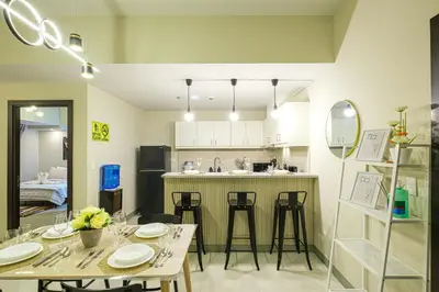 a kitchen and dining room with a table and chairs at Premium 3BR Suite UptownBGC w/ Bathtub & Balcony in Manila