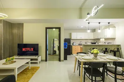 a living room and kitchen with a table and chairs at Premium 3BR Suite UptownBGC w/ Bathtub & Balcony in Manila
