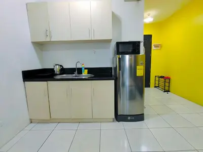 a kitchen with a sink and a refrigerator at HOYA Aparthotel In Malate in Manila