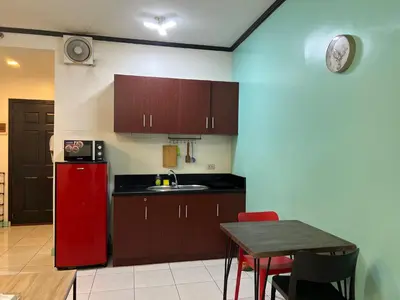 a kitchen with a red refrigerator and a table at HOYA Aparthotel In Malate in Manila
