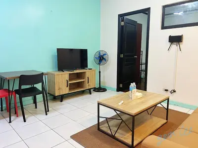 a living room with a table and a tv at HOYA Aparthotel In Malate in Manila