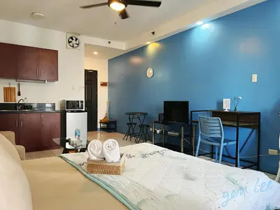 a living room with a bed and a kitchen at HOYA Aparthotel In Malate in Manila