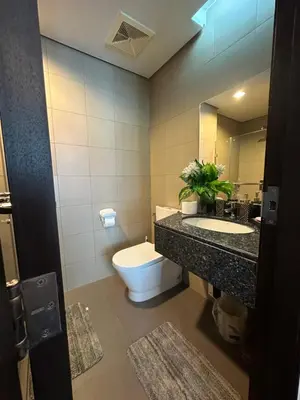 a bathroom with a toilet and a sink and a mirror at Condo in BGC near Grand Hyatt Hotel in Manila