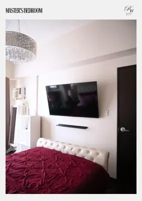 a bedroom with a bed with a tv on the wall at Condo in BGC near Grand Hyatt Hotel in Manila