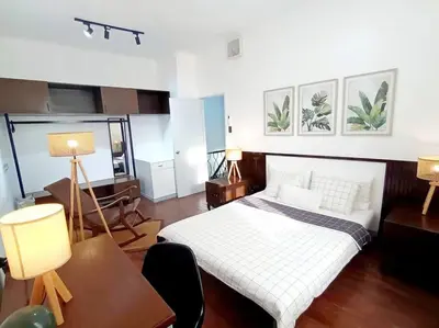 a bedroom with a bed and a desk and two lamps at 2A2J Apartments - 2 Bedroom in Manila