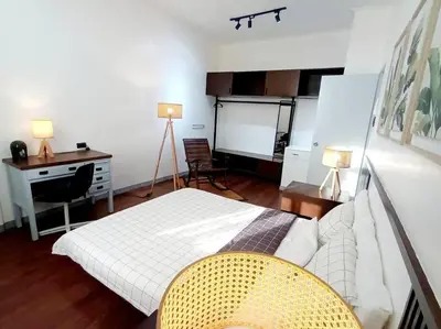a bedroom with a bed and a desk and a table at 2A2J Apartments - 2 Bedroom in Manila