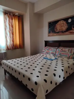 a bedroom with a bed with a black and white comforter at 5 Years Legit Staycation Infront of Moa, 2 Bedroom with Balcony at Sea Residences Tower A, Near Arena , Smx, Picc, Dfa Macapagal, World Trade, Star City, Ayala Mall, & Naia Sea Residences Tower A in Manila