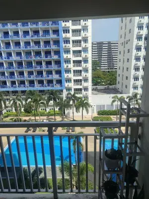 a balcony with a view of a pool and buildings at 5 Years Legit Staycation Infront of Moa, 2 Bedroom with Balcony at Sea Residences Tower A, Near Arena , Smx, Picc, Dfa Macapagal, World Trade, Star City, Ayala Mall, & Naia Sea Residences Tower A in Manila