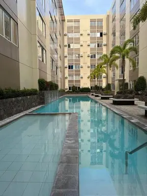 a large swimming pool in front of a building at Affordable Condo Near Nuvali in Silang